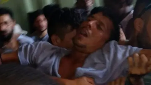 EPA A photo showing an asylum seekers appearing to faint in the Manus Island detention centre