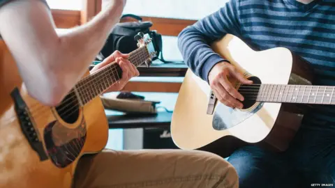 Getty Images guitar being taught at music lesson in school