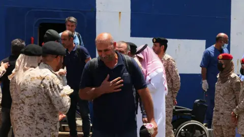 Getty Images Evacuees are welcomed by Saudi soldiers