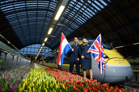 Jonathan Hordle Eurostar staff stand next to a train as the first service set off from St Pancras