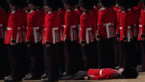 PA Media A member of the military faints during the Colonel's Review, for Trooping the Colour, at Horse Guards Parade in London, ahead of the King's Birthday Parade next Saturday