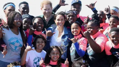 Getty Images Prince Harry and Meghan pose with surf mentors as they visit Waves for Change