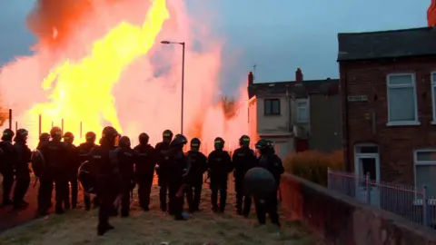 Police officers in riot gear at the Bloomfield walkway bonfire