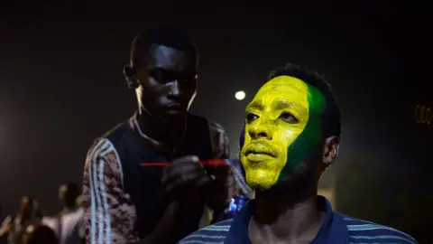 AFP A protester having his face painted in the colours of the old Sudanese flag in Khartoum, Sudan