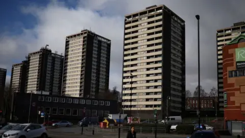 Reuters A woman walks in front of the Seven Sisters residential tower blocks