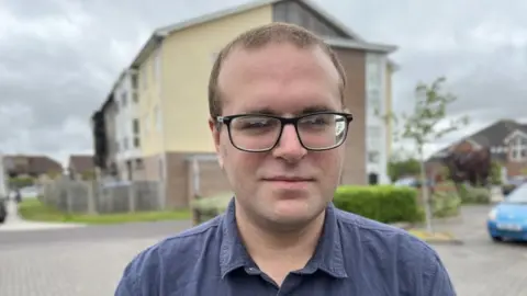 Ben Appleby standing outside some flats