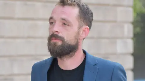 PA Media Jamie Arnold leaving Wolverhampton Crown Court after he pleaded not guilty to a charge alleging he racially abused Rio Ferdinand