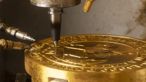 The Royal Mint Gold coin in the laser cutting machine