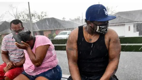 people evacuate from a flooded neighborhood in LaPlace, Louisiana on 30 August, 2021