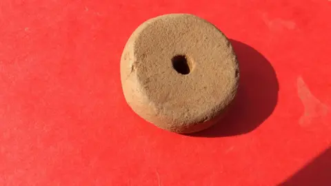 Stone wheel thought to be a spindle whorl for weaving.