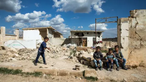 Getty Images Children playing in ruins of Syria's war