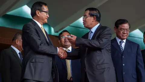 Getty Images Sam Rainsy and Hun Sen shake hands