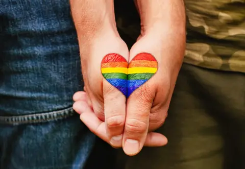 Getty   Rainbow heart drawing on hands.