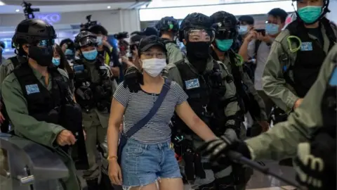 EPA Police detain a woman, (C), during a protest in a shopping mall in Hong Kong, China, 06 July 2020. Several dozen protesters held up sheets of blank paper after the government issued a statement linking the â€˜Liberate Hong Kong, revolution of our timesâ€™ slogan, used during mall protests, to separatism.