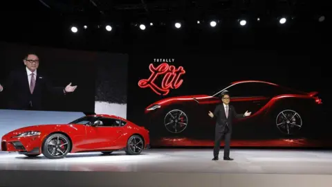 Getty Images Akio Toyoda, President of Toyota Motor Corporation, stands with The 2020 Toyota Supra rear-wheel-drive sports coupe at its reveal at the 2019 North American International Auto Show during Media preview days on January 14, 2019 in Detroit, Michigan