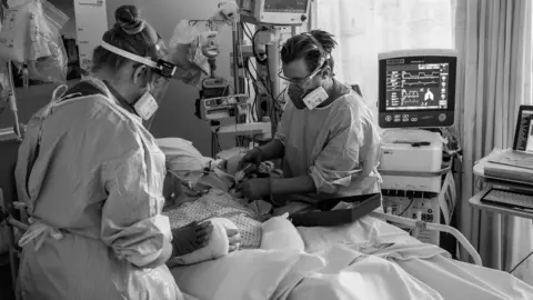 Tom Warburton Patient in Covid ICU being cared for by RVI staff (L-R) Lorna-Beth and Gareth