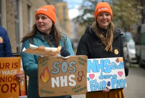 DANIEL LEAL People hold placards on a picket line outside Great Ormond Street Children's Hospital in London