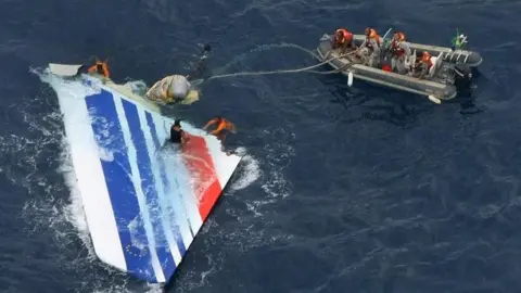 AFP PHOTO / BRAZILIAN NAVY Divers recover part of the tail section from the Air France plane that plunged into the Atlantic Ocean. Photo: May 2011