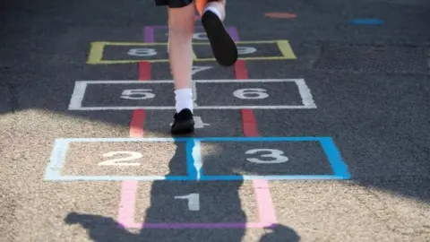 Getty Images Schoolgirl playing hopscotch in the playground