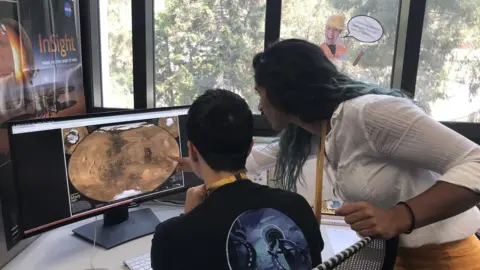 Farah Alibay/JPL/NASA Two people look at a screen with a map of Mars - we are looking over their shoulders
