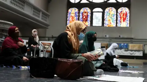 Reuters Women wearing headscarves and face masks attend Friday prayers at a Berlin church