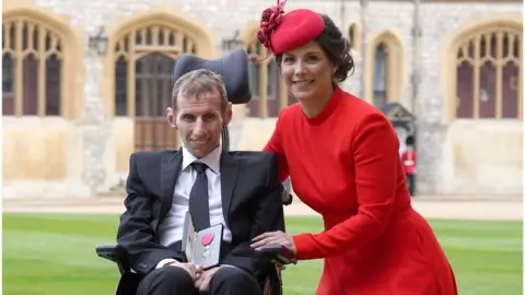 Steve Parsons-WPA Pool/Getty Images Rob Burrow with wife Lindsey after he was made an MBE during an investiture ceremony at Windsor Castle on 5 April, 2022