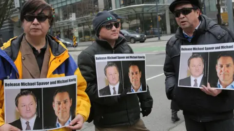 Getty Images Protesters hold signs calling for the release of Michael Spavor and Michael Kovrig