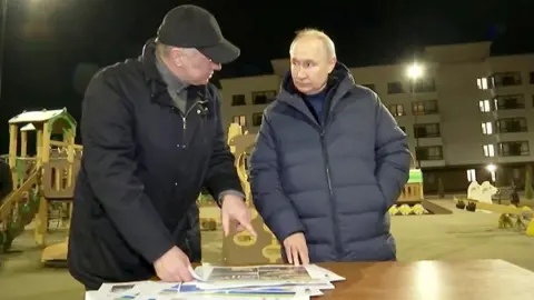 Reuters Russian President Vladimir Putin listens to Deputy Prime Minister Marat Khusnullin outside residential block in Mariupol