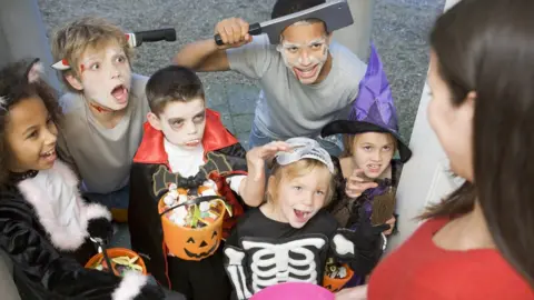 Getty Images Six children trick or treating on Halloween