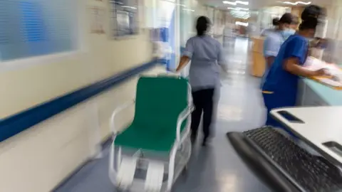 Getty Images Staff moving through a hospital corridor