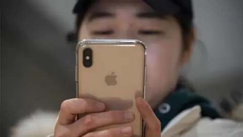 AFP Chinese person and iPhone