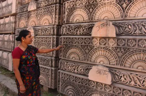 Getty Images A Hindu woman looks at stone slabs earmarked for the construction of a Hindu temple at a workshop in Ayodhya in 2012.