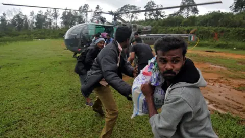 Reuters People unloading goods from an army helicopter