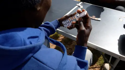 BBC Migrants in the Calais camp play dominos