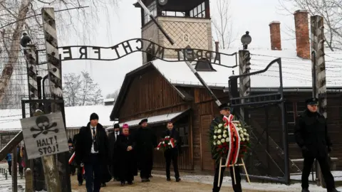 Reuters People arrive to lay wreaths at the "death wall" at the former Nazi German concentration and extermination camp Auschwitz