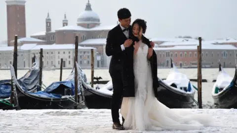 AFP A couple poses in St. Mark's Square in Venice