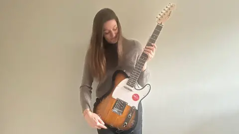 Friends of Rode and Norton schools Picture of lady holding guitar