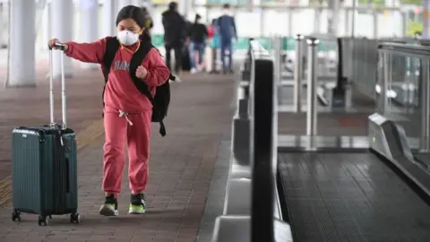 AFP/Getty Images A girl wearing a facemask crosses from mainland China to Hong Kong. Photo: 8 February 2020