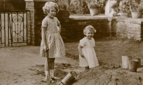 Chronicle/Alamy Stock Photo Two young girls play in a sandpit