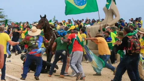 Getty Images A military police officer fall from his horse during clashes with rioters in Brasília on 8 January