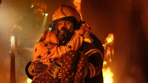 Getty Images Fireman carrying child