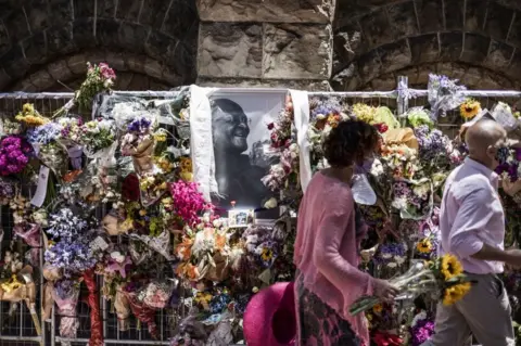 AFP People bring flowers to leave in tribute to the late Archbishop Desmond Tutu