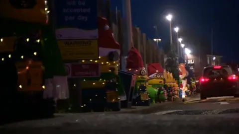 Old tyres stacked up and painted to look like Minions dressed up in Santa hats