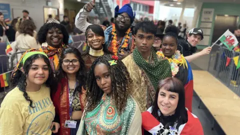Jon Wright/BBC A crowd of young people in colourful outfits from Asia, Africa and Europe