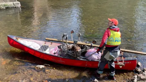 PaddlePeak Man with a canoe containing rubbish