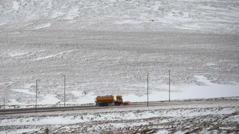 Getty Images A gritting lorry clears snow on the A672 near the M62 motorway