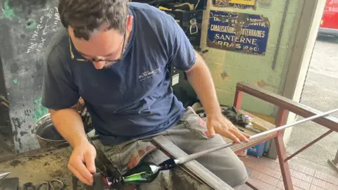 A man blowing a glass