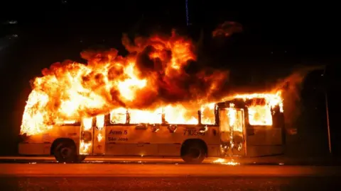 Reuters A bus is seen on fire as supporters of Brazil's President Jair Bolsonaro protest after supreme court justice Alexandre de Moraes ordered a temporary arrest warrant of indigenous leader Jose Acacio Serere Xavante for alleged anti-democratic acts, in Brasilia, Brazil, December 12, 2022.