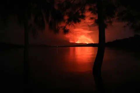 AFP This general view taken on 22 May 2021 from Tchegera Island outside Goma on the lake Kivu in the East of the Democratic Republic of Congo shows flame spewing from the Nyiragongo volcano.