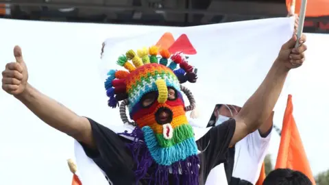 Getty Images A supporter of Andrés Arauz wears a ski mask at a rally in Quito, 7 April